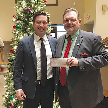 Lawyer at O'Brien law firm and client posing with check for christmas photo